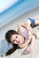 A woman laying on the sand on a beach.