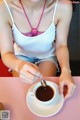 A woman sitting at a table with a cup of coffee.