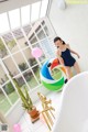 A woman in a bathing suit standing next to a bathtub.