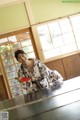 A woman in a kimono playing ping pong.