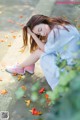 A woman sitting on the ground with her head in her hands.