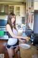 A woman in a maid outfit preparing food in a kitchen.